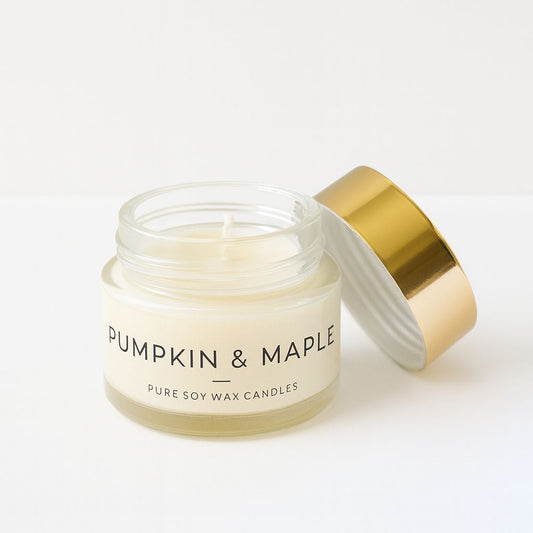 Candle jar labeled 'Pumpkin & Maple' with a gold lid on a white background